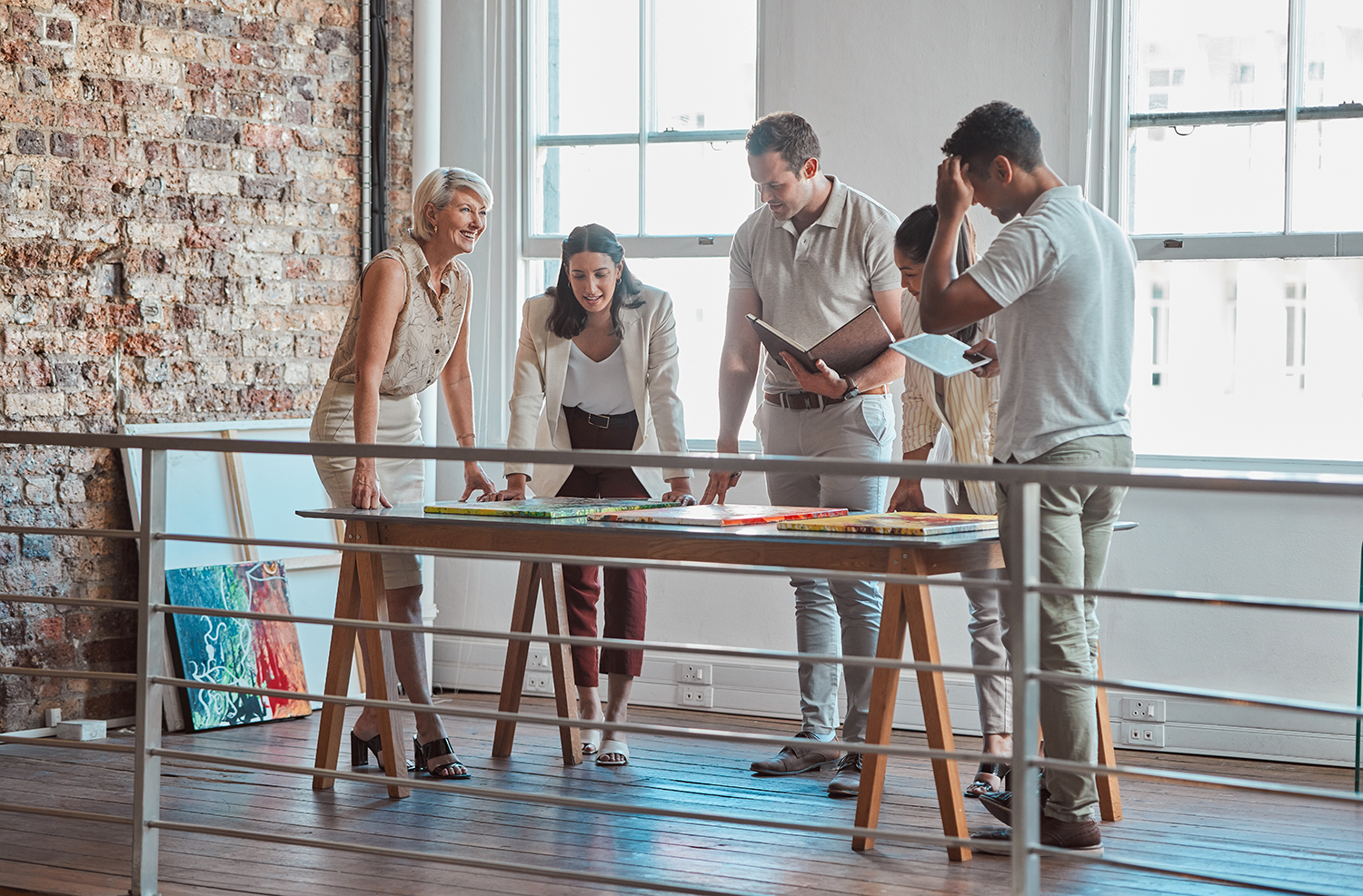Colleagues at an art gallery standing around a table talking